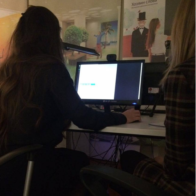 A girl sat observing a computer screen